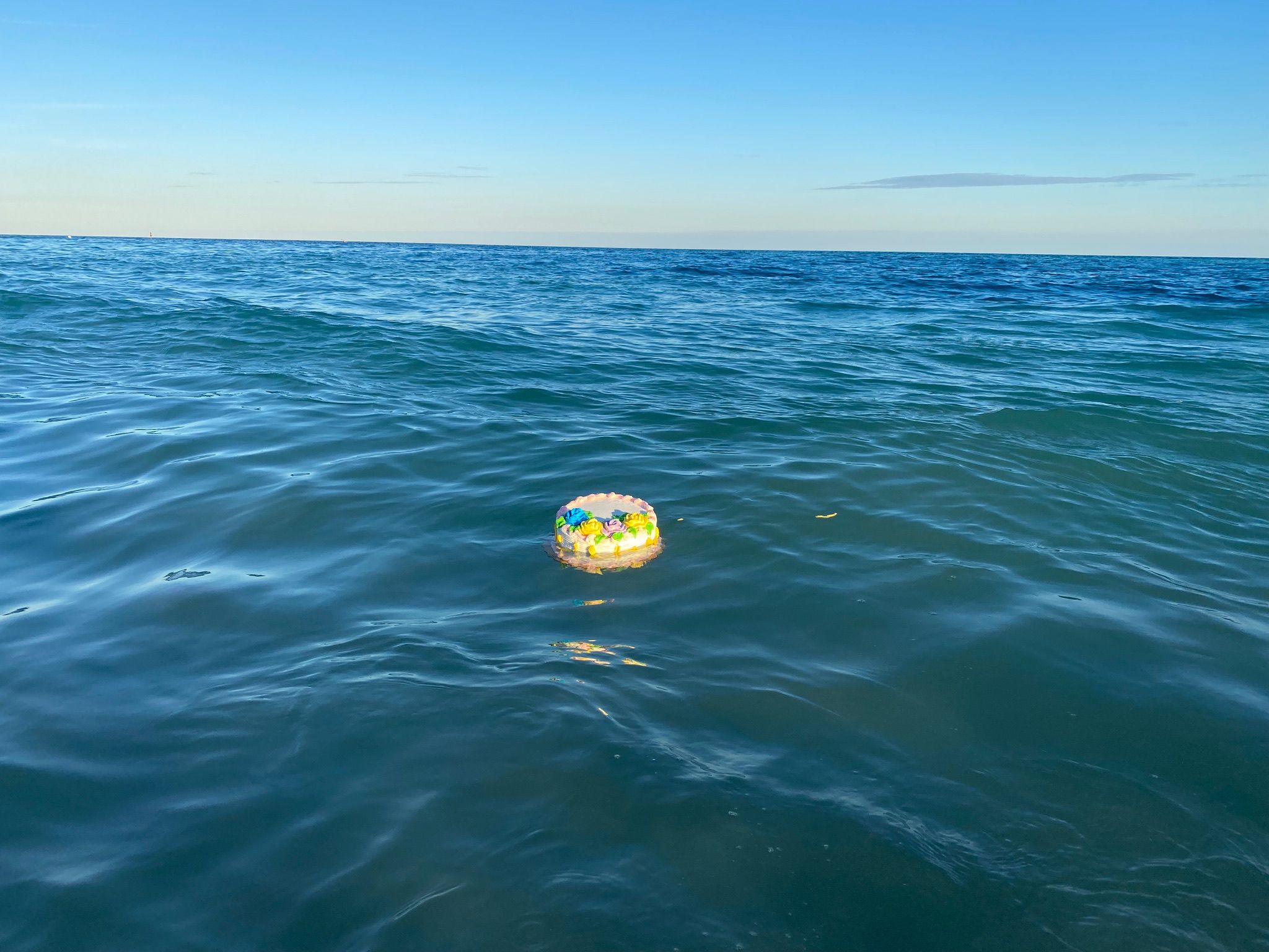 A decorated wreath floating in blue ocean water